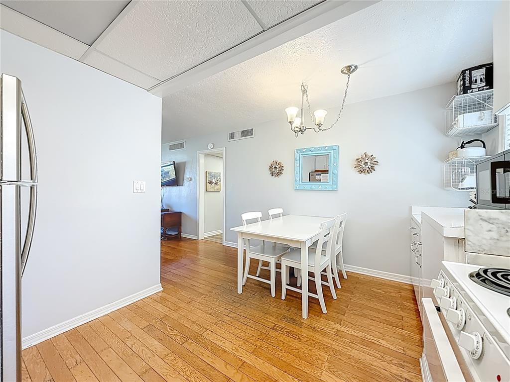 6700 Sunset Way, Unit 604 St. Pete Beach, FL 33706 - Photo 11 of 27 a view of a dining room with furniture and wooden floor