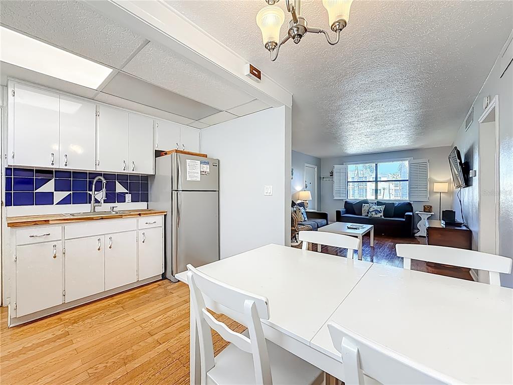 6700 Sunset Way, Unit 604 St. Pete Beach, FL 33706 - Photo 12 of 27 a kitchen that has a lot of cabinets in it and wooden floors