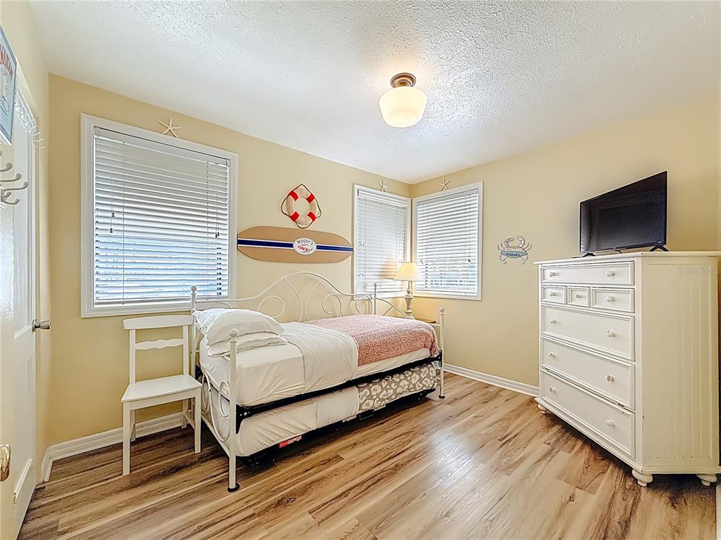 6700 Sunset Way, Unit 604 St. Pete Beach, FL 33706 - Photo 14 of 27 a bedroom with a bed and a tv