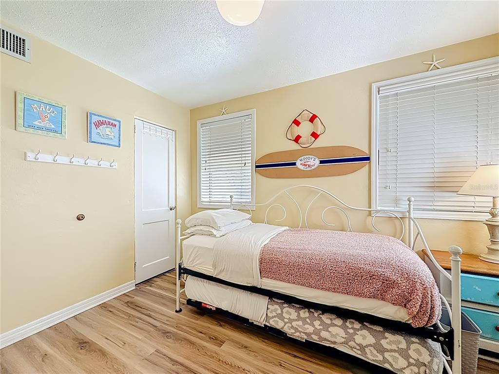 6700 Sunset Way, Unit 604 St. Pete Beach, FL 33706 - Photo 15 of 27 a bedroom with a bed and wooden floor