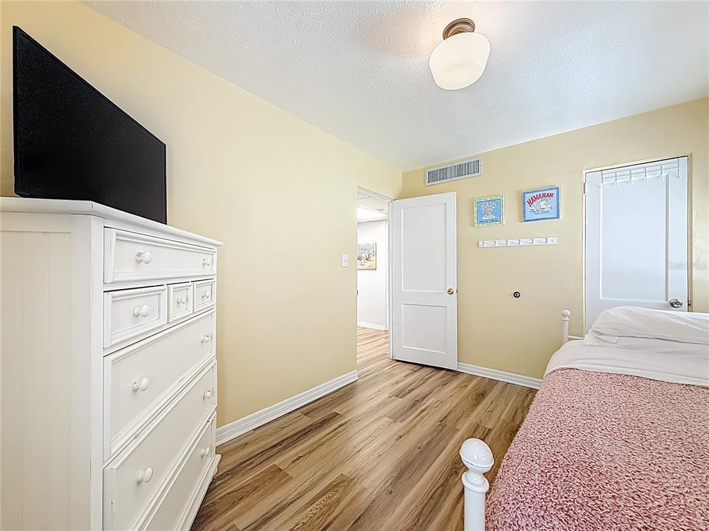 6700 Sunset Way, Unit 604 St. Pete Beach, FL 33706 - Photo 16 of 27 a bedroom with a bed and a flat screen tv