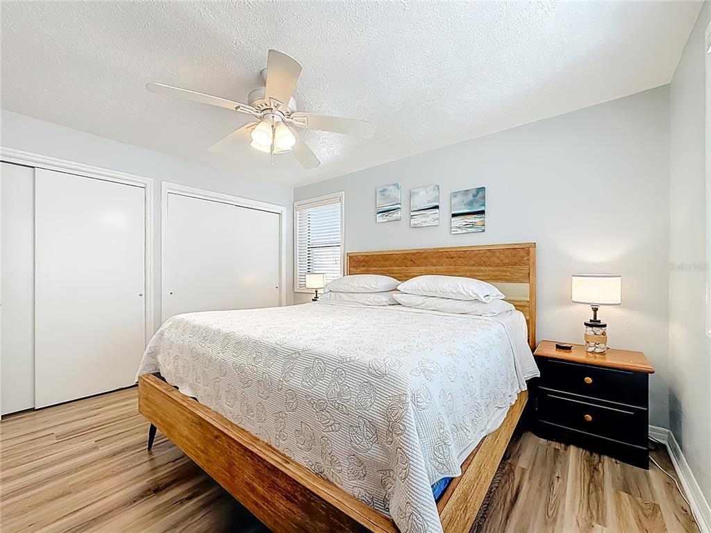 6700 Sunset Way, Unit 604 St. Pete Beach, FL 33706 - Photo 18 of 27 a bedroom with a bed and wooden floor