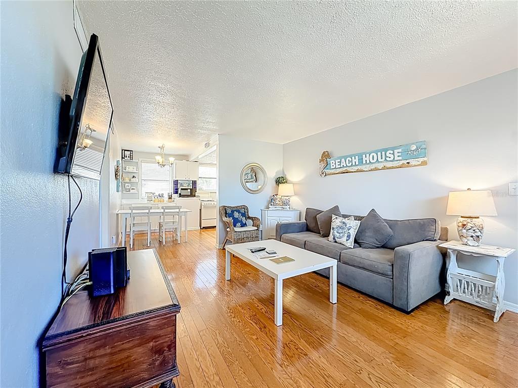 6700 Sunset Way, Unit 604 St. Pete Beach, FL 33706 - Photo 7 of 27 a living room with furniture and a flat screen tv