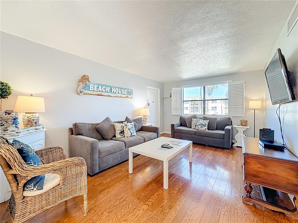 6700 Sunset Way, Unit 604 St. Pete Beach, FL 33706 - Photo 8 of 27 a living room with furniture and a flat screen tv