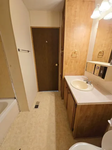 a bathroom with a sink and mirror with toilet