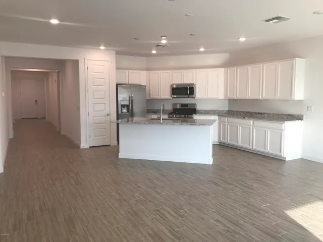 a view of kitchen with wooden floor and electronic appliances