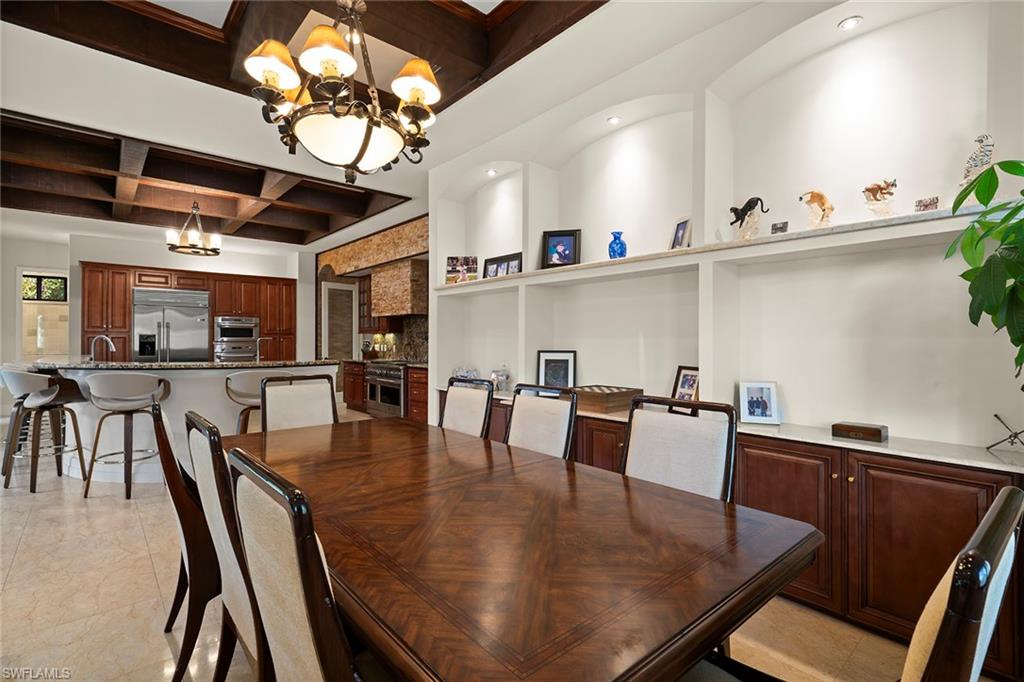 2605 64th Street Southwest Naples, FL 34105 - Photo 16 of 45 a dining room with furniture a chandelier and wooden floor