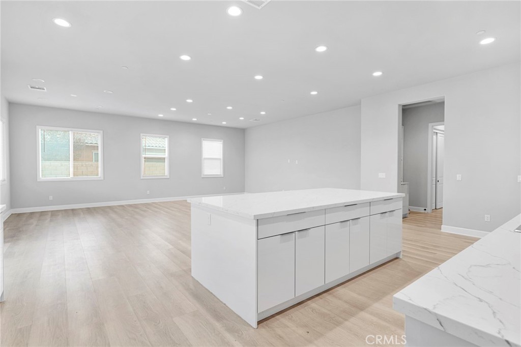 12925 Davona Dale Road Apple Valley, CA 92308 - Photo 10 of 44 a large white kitchen with kitchen island granite countertop a large window