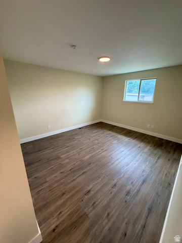 450 13800 South, Unit 2 Draper, UT 84020 - Photo 7 of 21 Spacious room featuring wood-finish flooring, light-colored walls, white baseboards, a flush-mount ceiling light, and a window with white trim