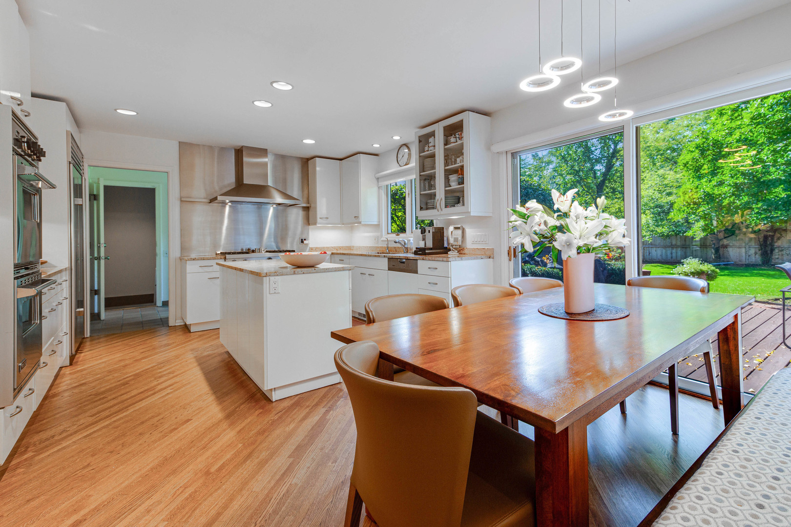1144 Mayfair Lane Glencoe, IL 60022 - Photo 8 of 23 an open kitchen with kitchen island a large window cabinets stainless steel appliances and a dining table