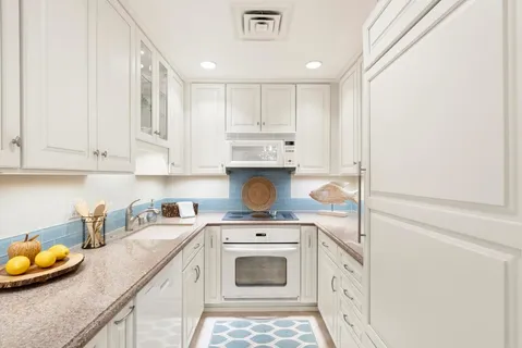 a kitchen with stainless steel appliances granite countertop a sink a stove and cabinets