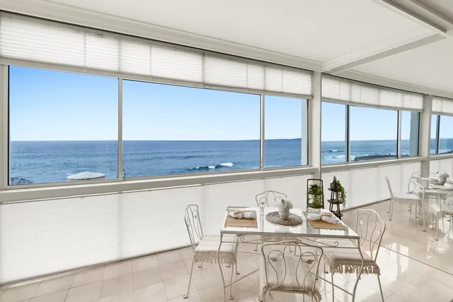 a kitchen with a white stove top oven and white cabinets with wooden floor
