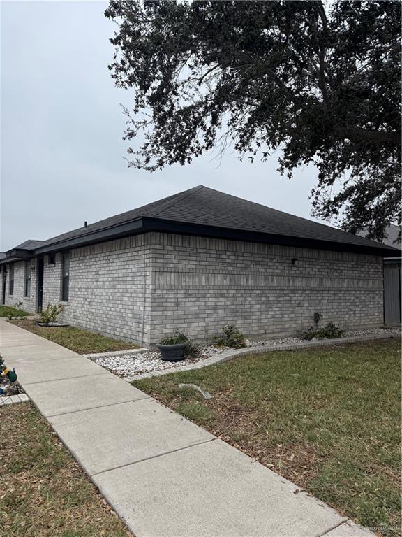 View of side of home with a lawn