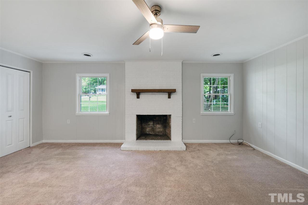 7409 Fiesta Way Raleigh, NC 27615 - Photo 12 of 30 a living room with a fireplace and a window