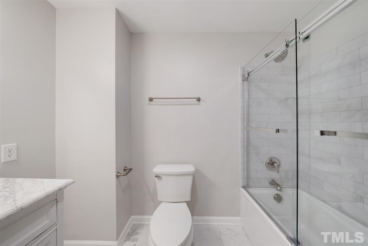 7409 Fiesta Way Raleigh, NC 27615 - Photo 17 of 30 a bathroom with a toilet a sink and shower