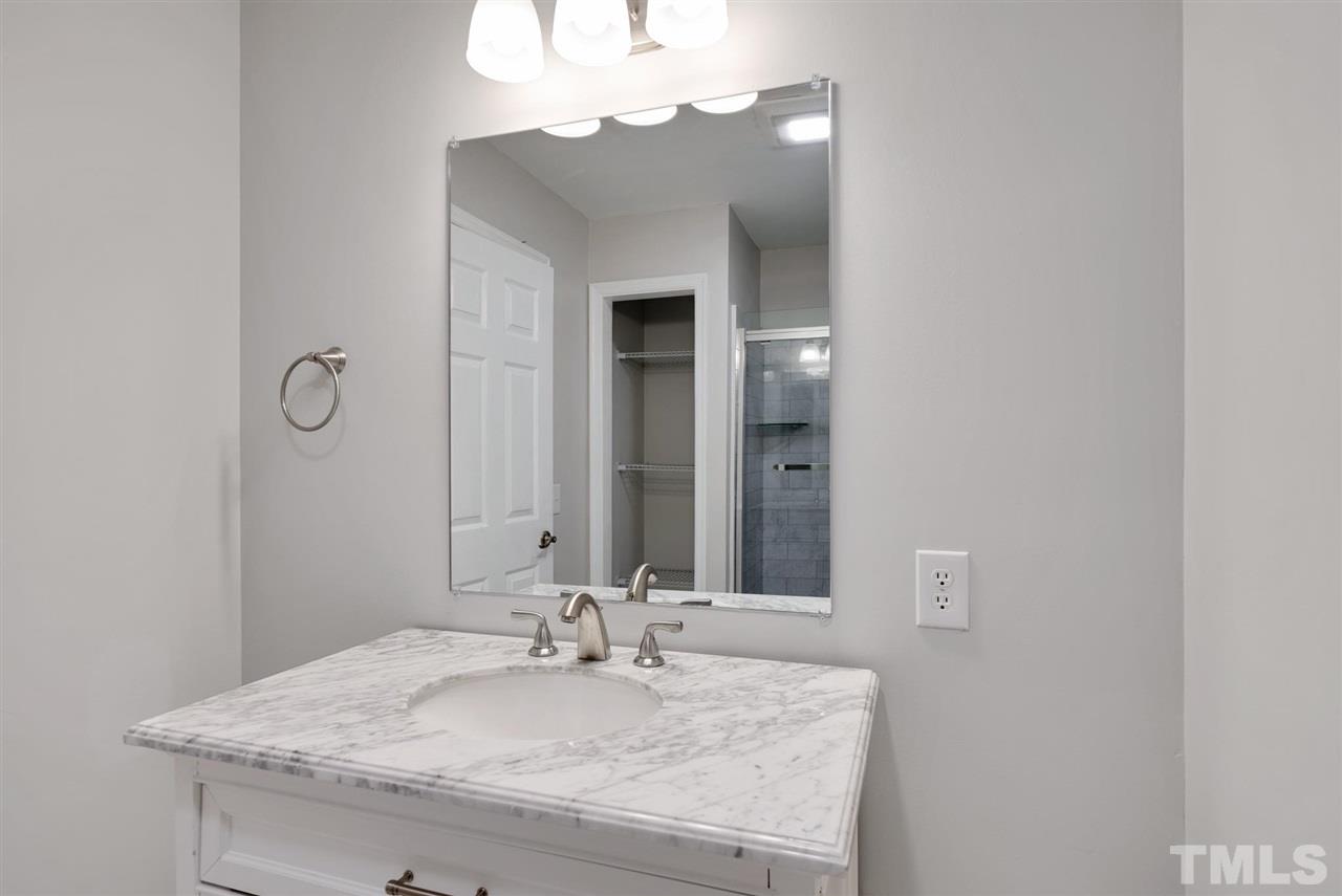7409 Fiesta Way Raleigh, NC 27615 - Photo 18 of 30 a bathroom with a granite countertop sink and a mirror