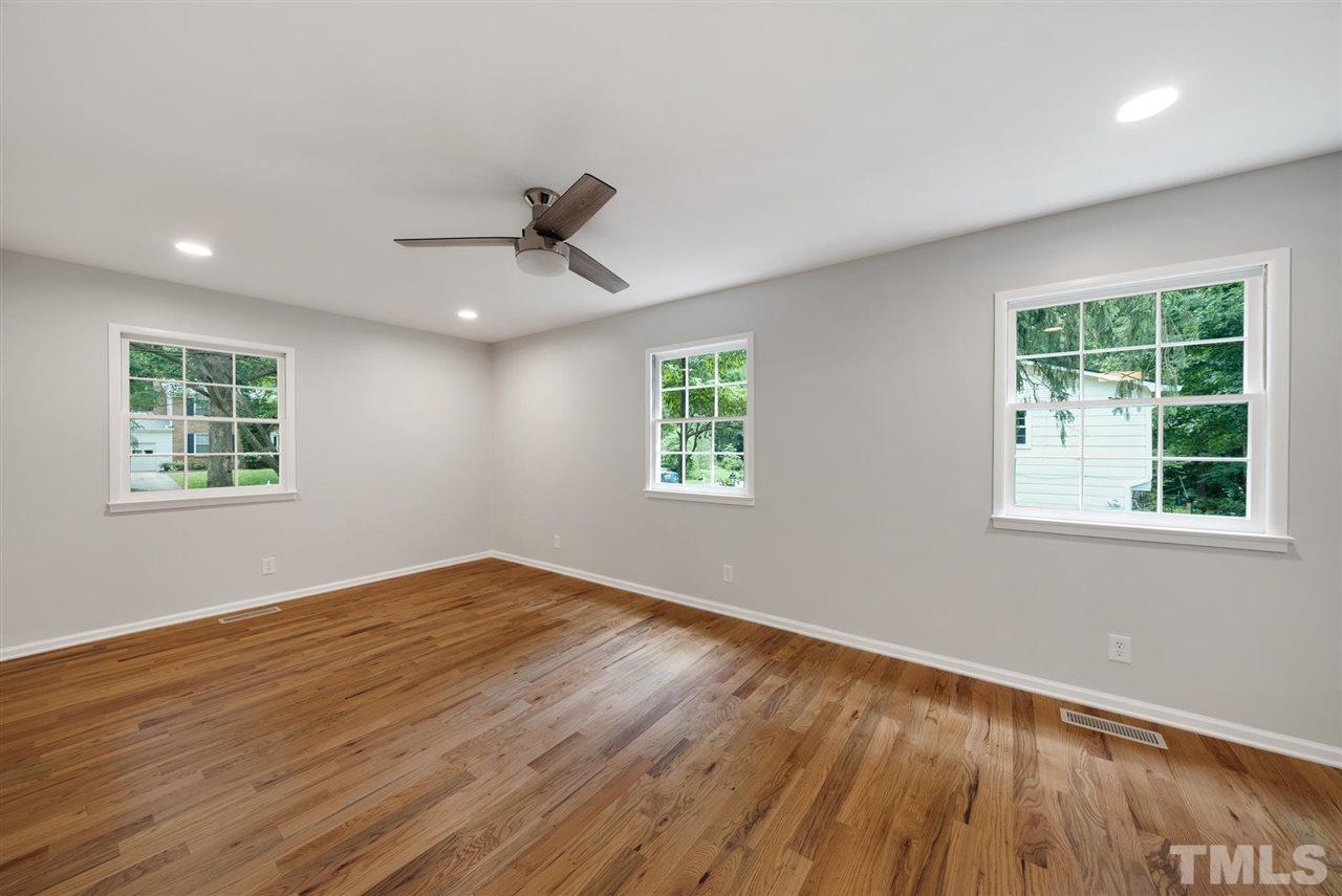 7409 Fiesta Way Raleigh, NC 27615 - Photo 21 of 30 a view of an empty room with a window and wooden floor