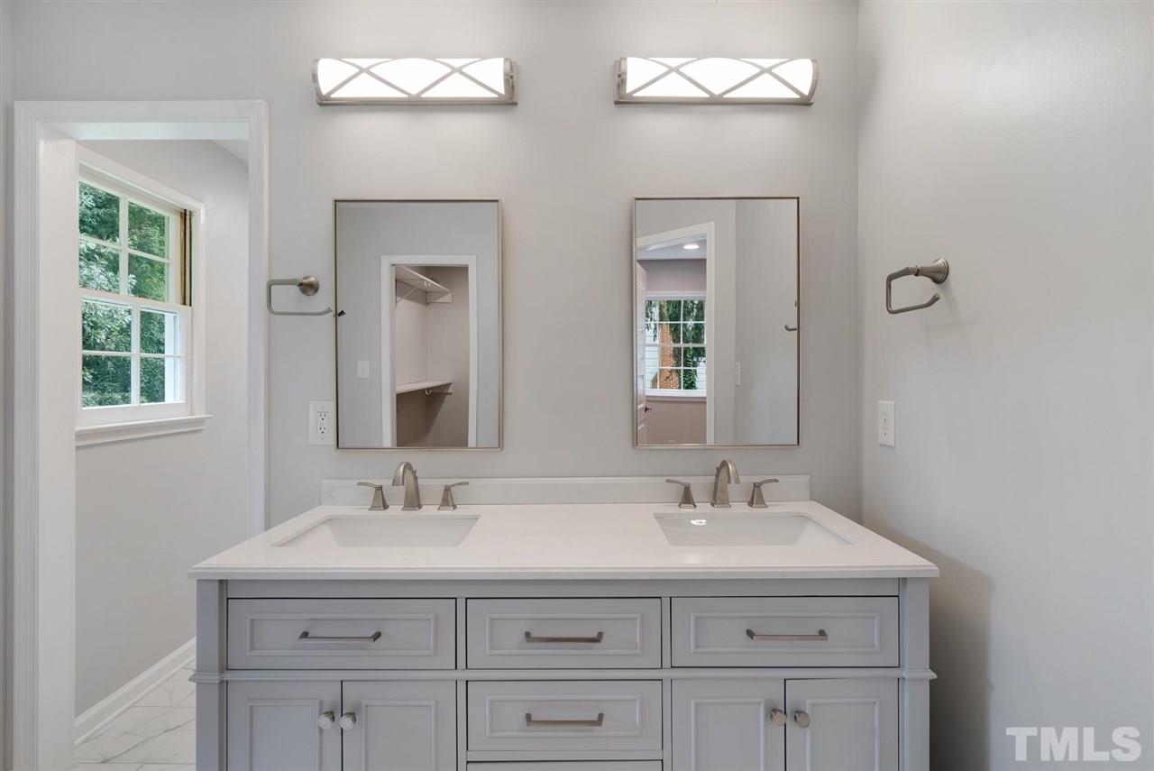 7409 Fiesta Way Raleigh, NC 27615 - Photo 22 of 30 a bathroom with double sink and a mirror