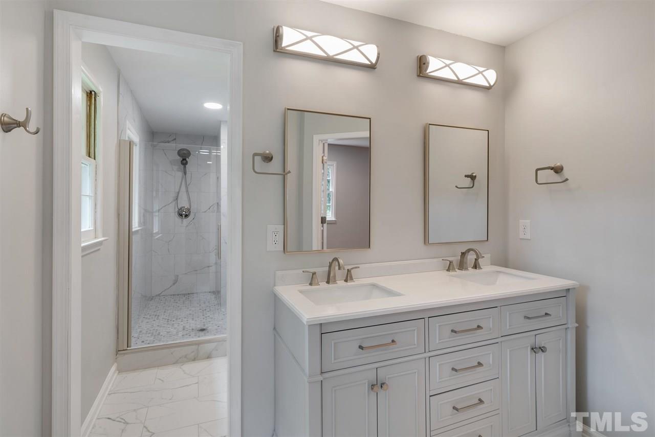 7409 Fiesta Way Raleigh, NC 27615 - Photo 23 of 30 a bathroom with 2 sink shower and a mirror