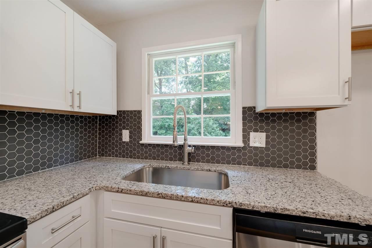 7409 Fiesta Way Raleigh, NC 27615 - Photo 8 of 30 a kitchen with granite countertop a sink window and cabinets