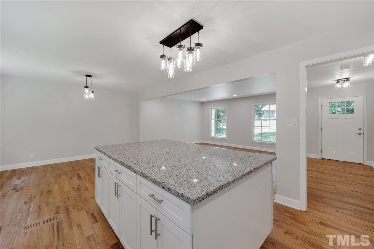 7409 Fiesta Way Raleigh, NC 27615 - Photo 9 of 30 a kitchen with a sink granite counter tops and a view of living room