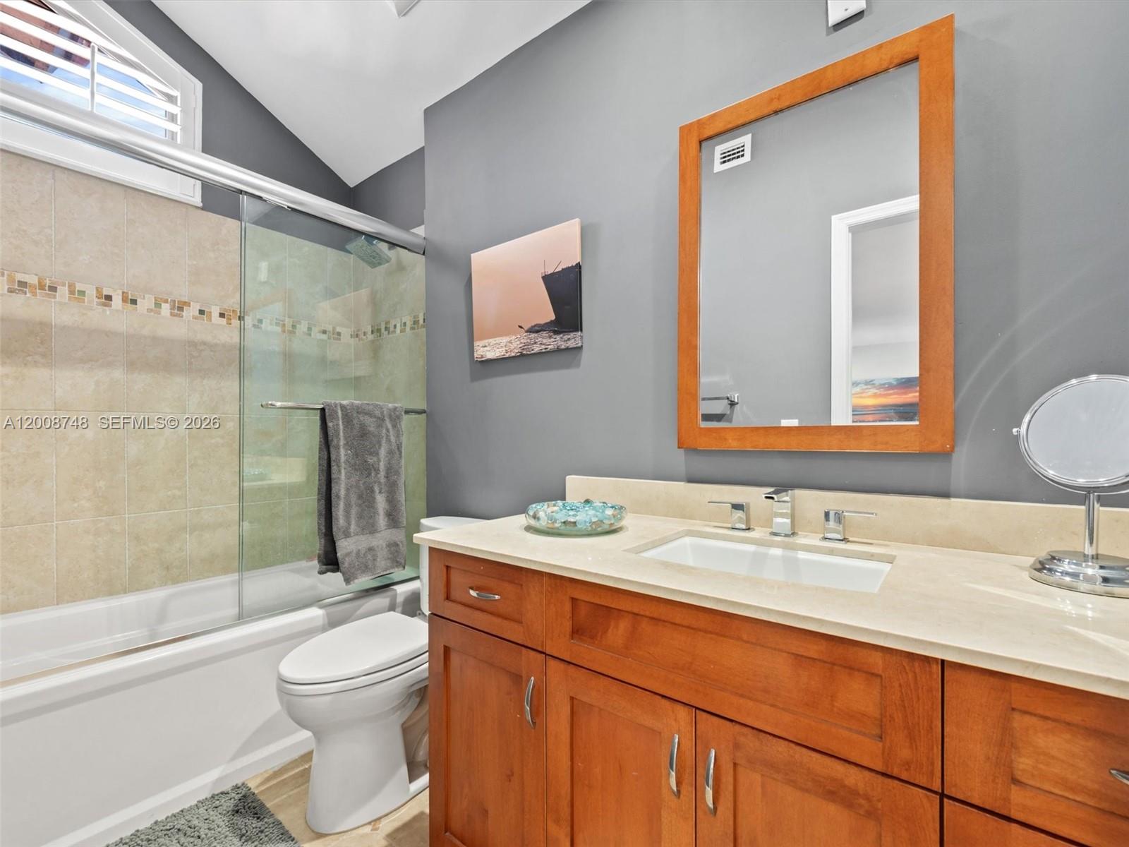 8889 Southwest 78th Court Miami, FL 33156 - Photo 14 of 23 a bathroom with a granite countertop sink toilet a mirror a vanity and shower