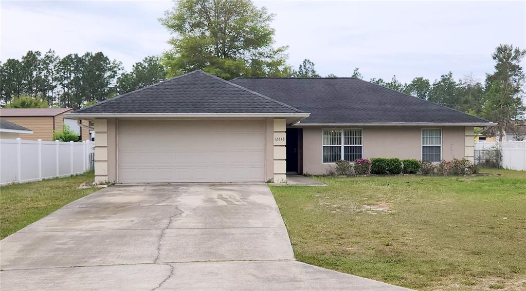 12848 Southwest 77th Circle Ocala, FL 34473 - Photo 1 of 1 a front view of a house with a yard and garage