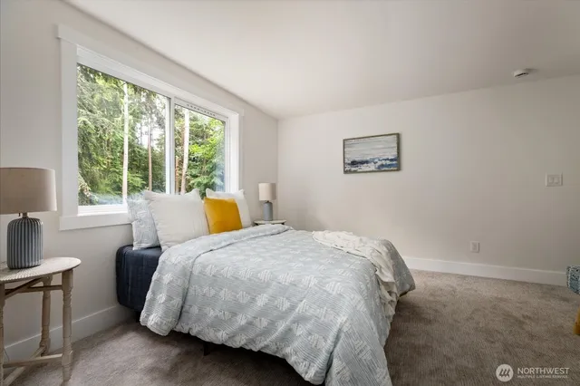 a bedroom with a bed and a large window