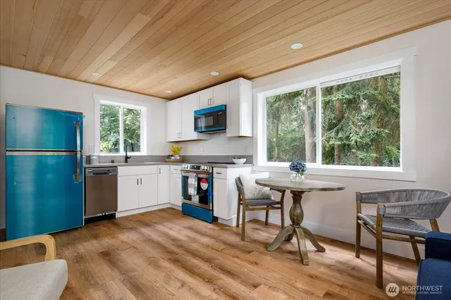 a kitchen with a table chairs a refrigerator and a sink