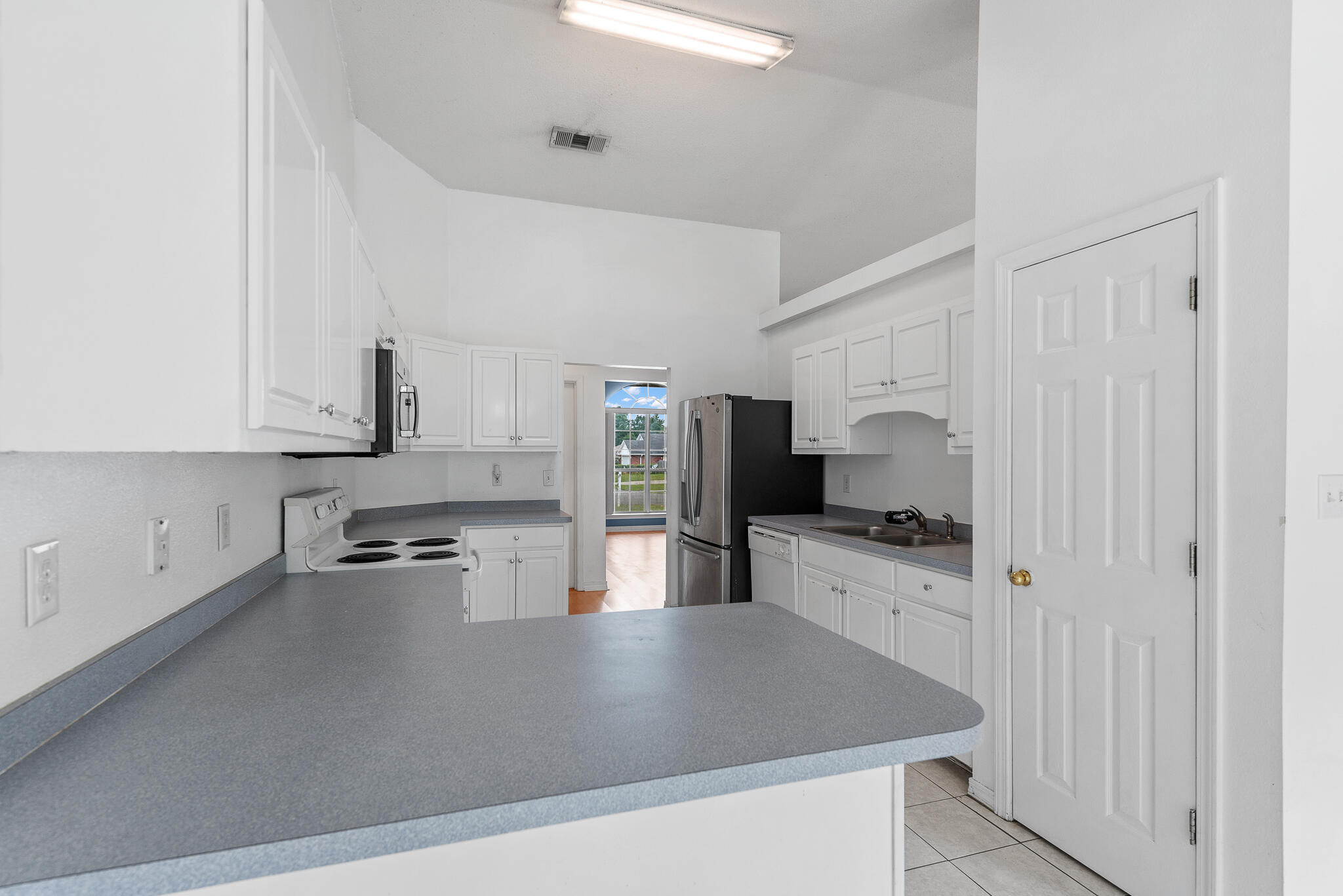 2246 Titanium Drive Crestview, FL 32536 - Photo 11 of 28 a kitchen with stainless steel appliances a sink a stove top oven a counter space and cabinets