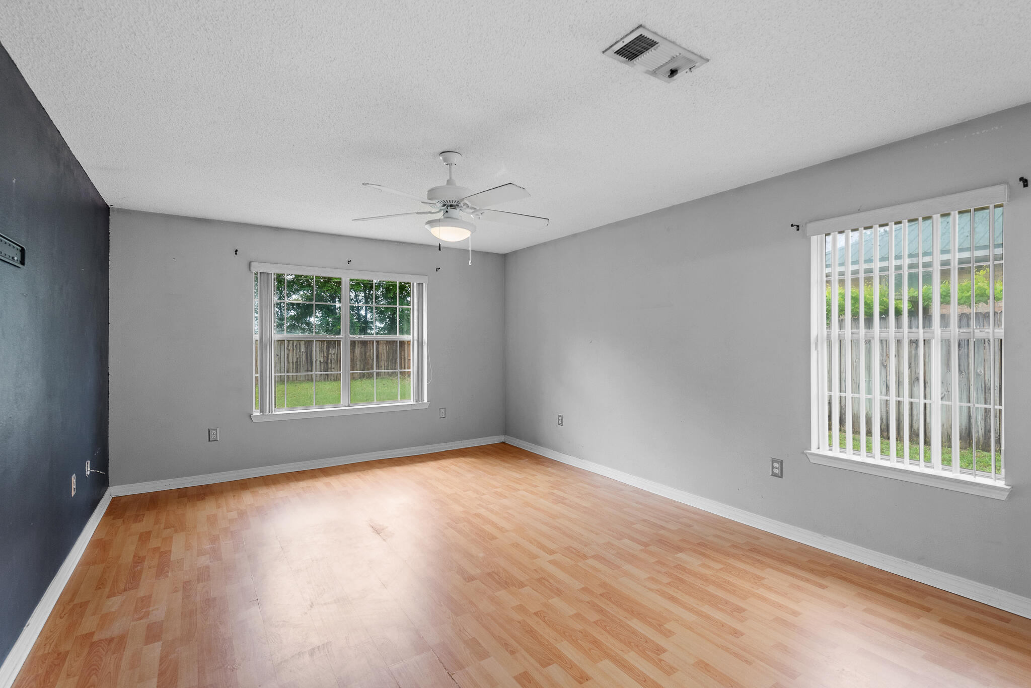 2246 Titanium Drive Crestview, FL 32536 - Photo 14 of 28 a view of an empty room with a window and wooden floor