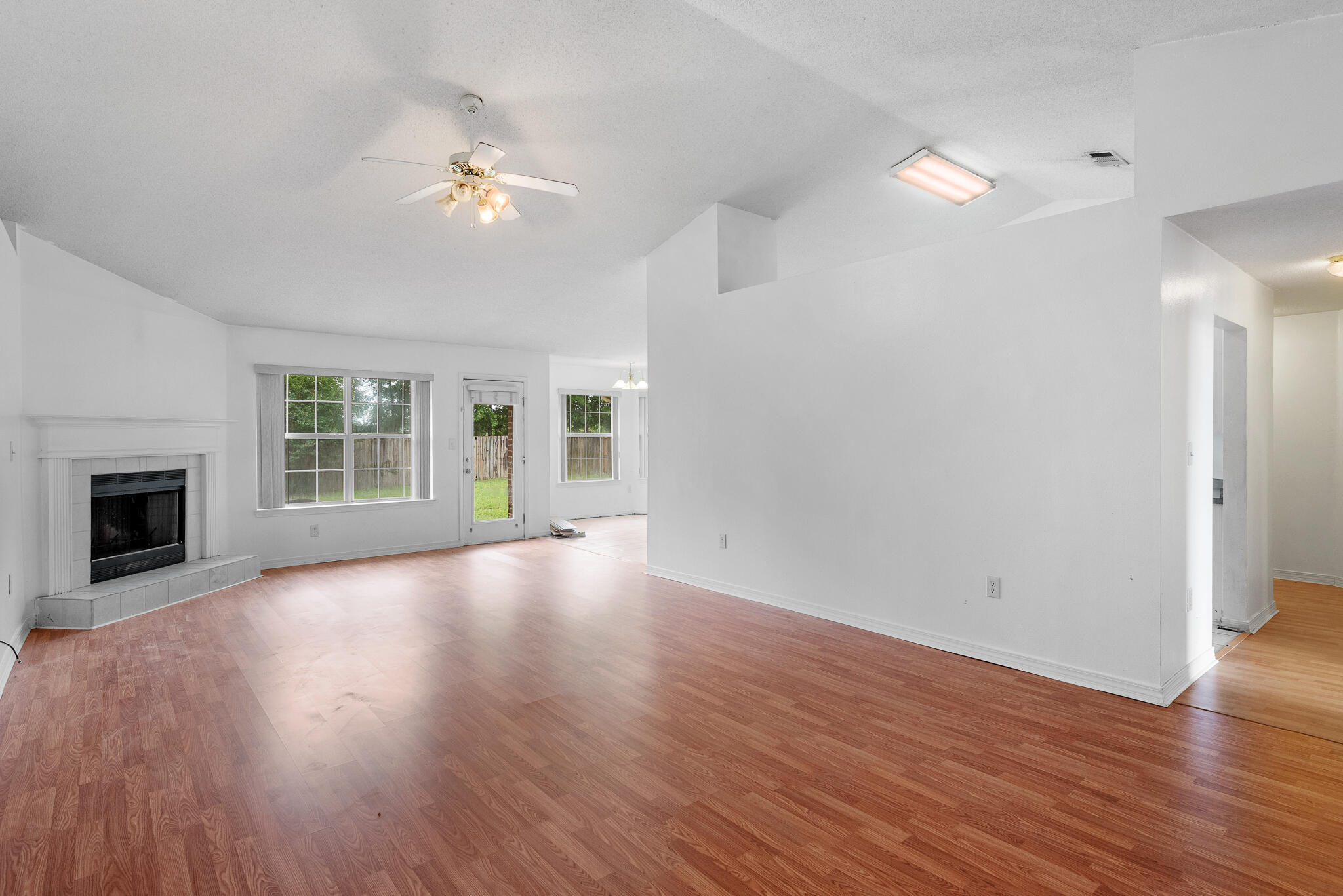 2246 Titanium Drive Crestview, FL 32536 - Photo 5 of 28 a view of an empty room with wooden floor fireplace and a window