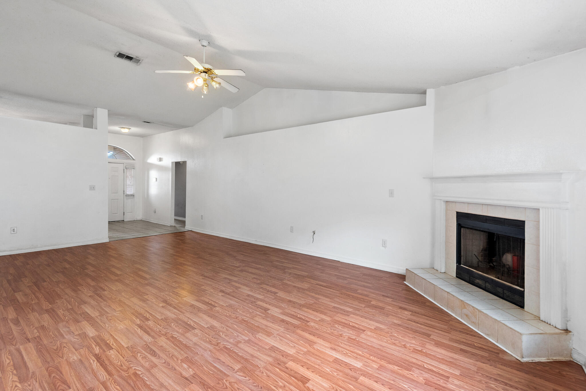 2246 Titanium Drive Crestview, FL 32536 - Photo 7 of 28 a view of an empty room with wooden floor fireplace and a window