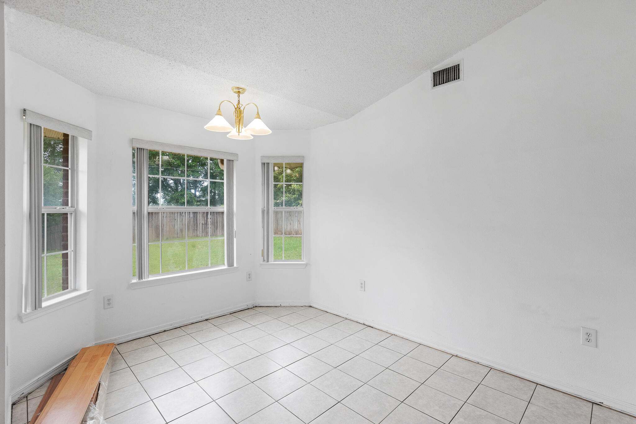 2246 Titanium Drive Crestview, FL 32536 - Photo 8 of 28 an empty room with windows and chandelier fan