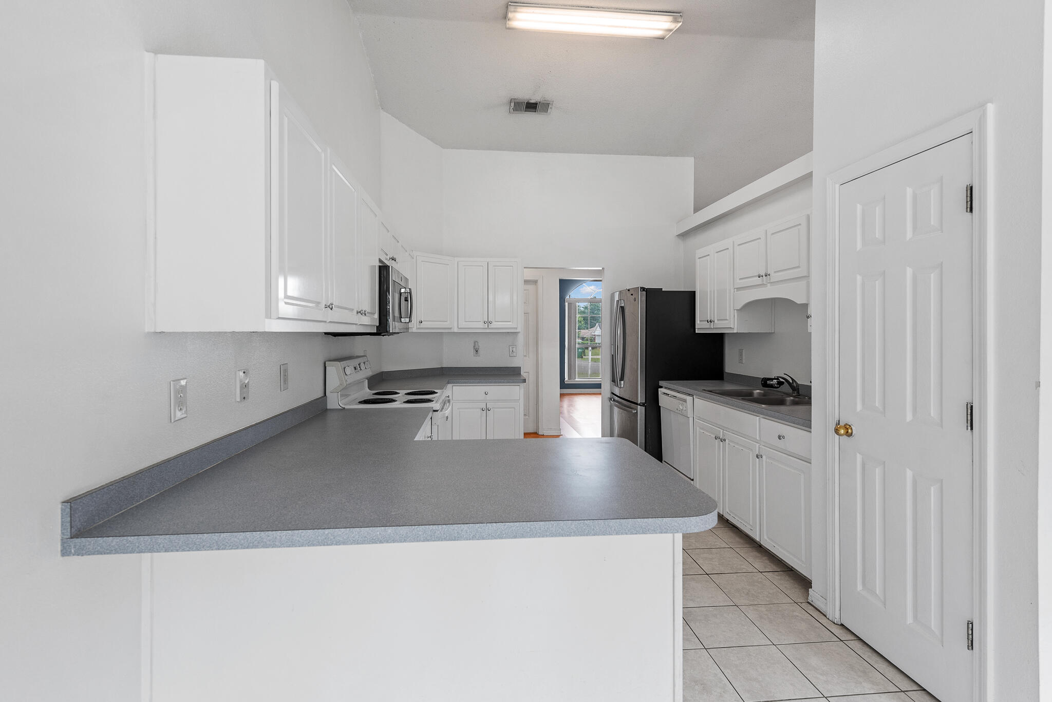2246 Titanium Drive Crestview, FL 32536 - Photo 9 of 28 a kitchen with stainless steel appliances a sink a stove top oven a counter space and cabinets