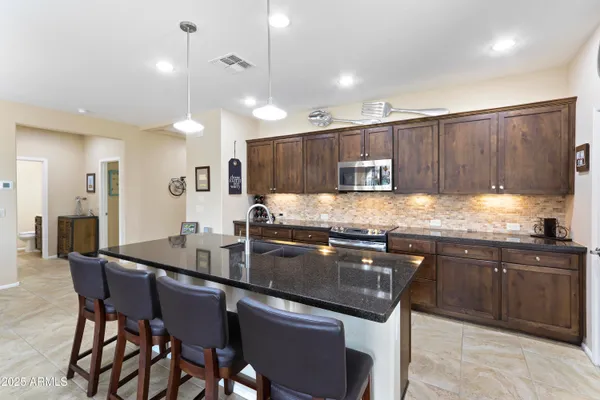 a kitchen with granite countertop a sink counter top space appliances and cabinets
