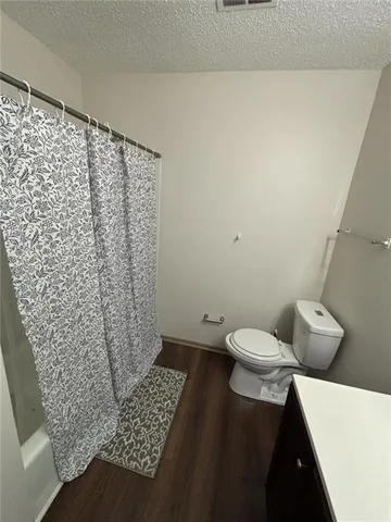 a bathroom with a toilet and a shower curtain