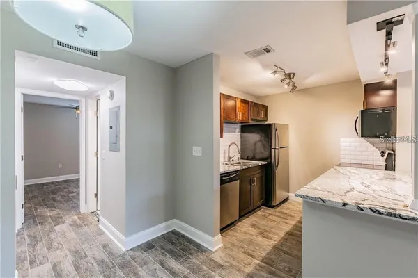 a kitchen with granite countertop a refrigerator stove and sink