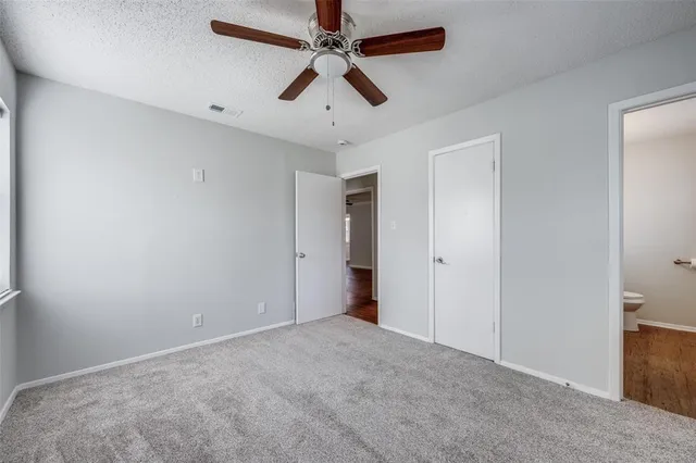 an empty room with chandelier fan
