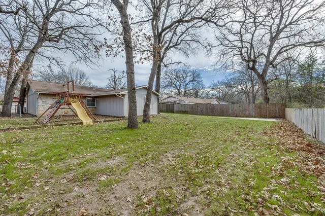 a view of a backyard with large trees