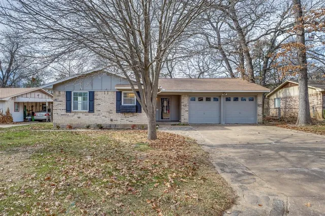 a view of a house with a yard and large tree
