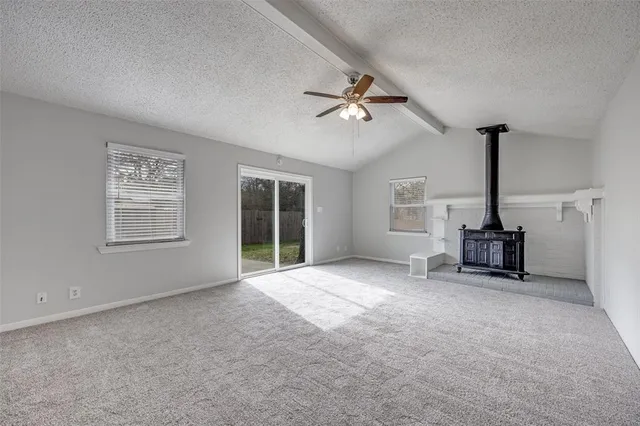 a view of empty room with windows and ceiling fan
