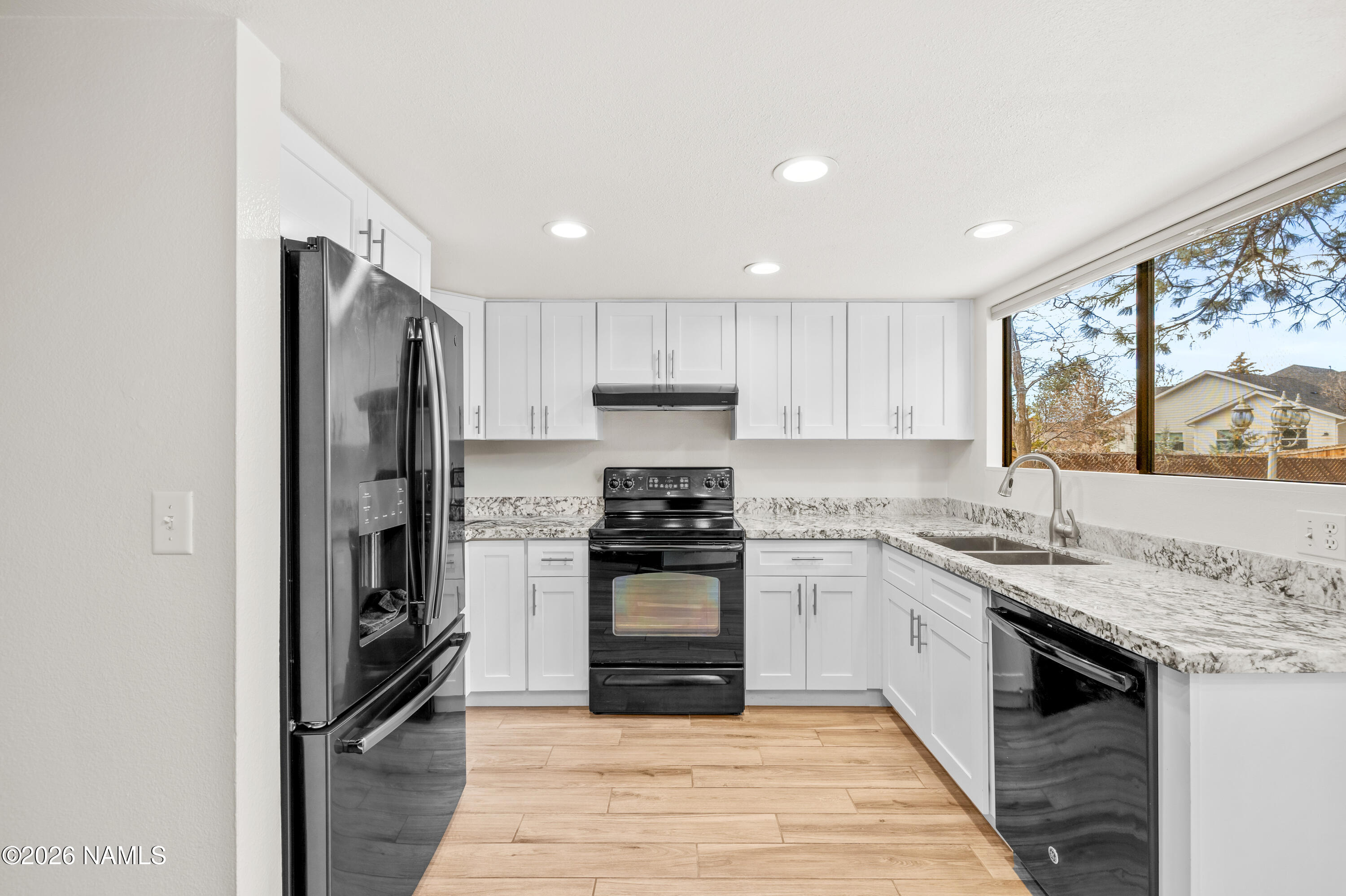 3971 North Swiss Road Flagstaff, AZ 86004 - Photo 13 of 43 a kitchen with stainless steel appliances granite countertop a stove top oven a sink and a refrigerator