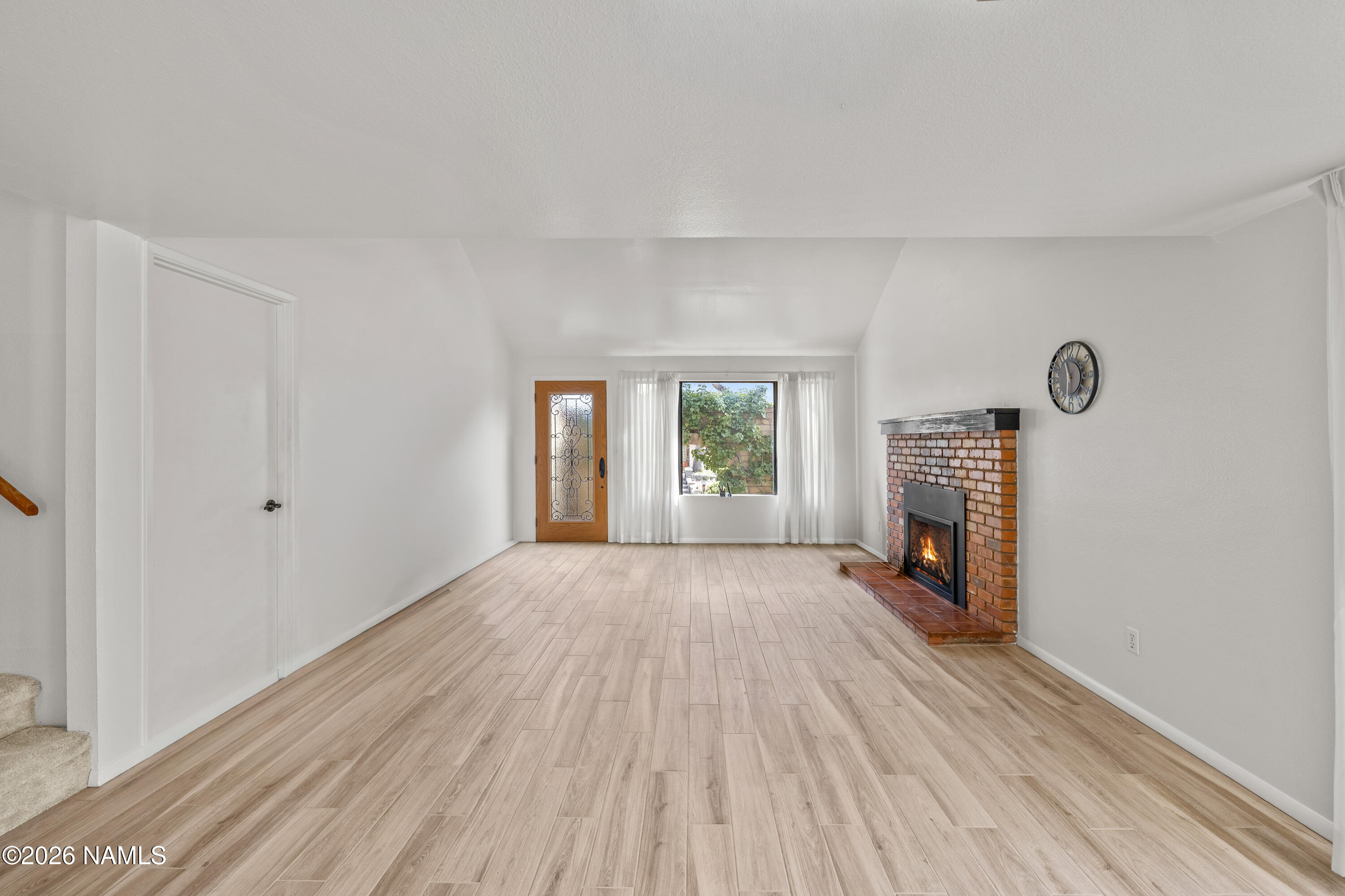 3971 North Swiss Road Flagstaff, AZ 86004 - Photo 8 of 43 a view of empty room with fireplace and wooden floor
