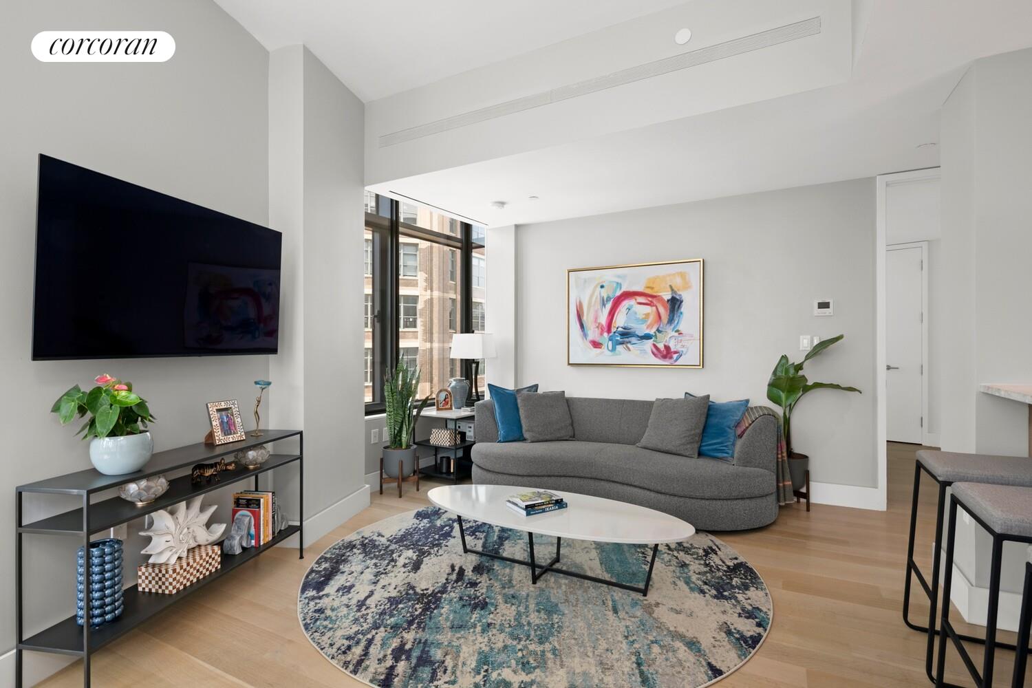 219 Hudson Street, Unit 6D Manhattan, NY 10013 - Photo 8 of 16 a living room with furniture and a flat screen tv