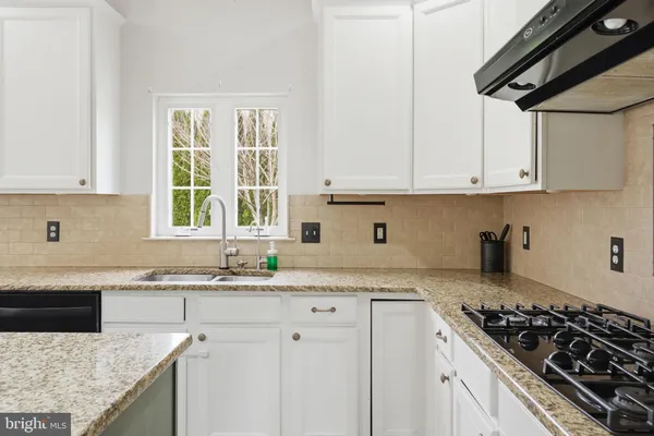 a kitchen with granite countertop a stove and a sink