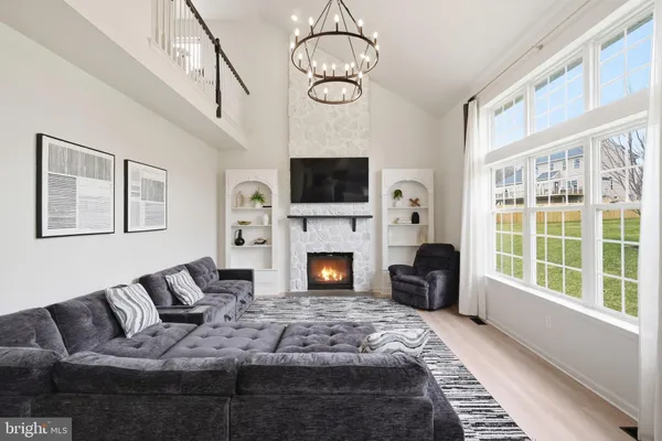 a living room with furniture a fireplace and a flat tv screen next to a window