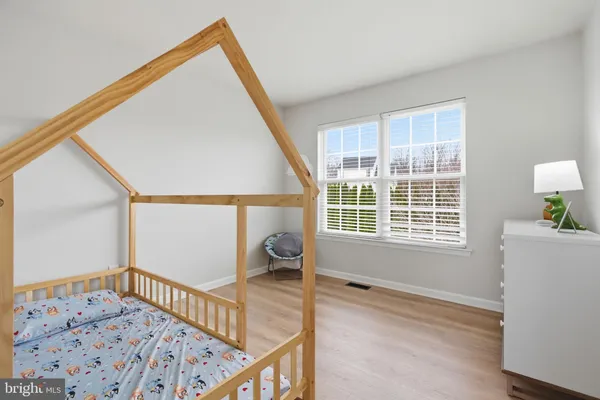 a view of a bedroom with wooden floor and windows