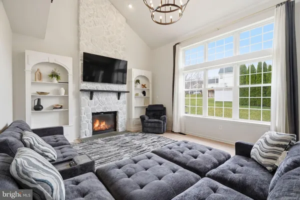 a living room with furniture a flat screen tv and a fireplace