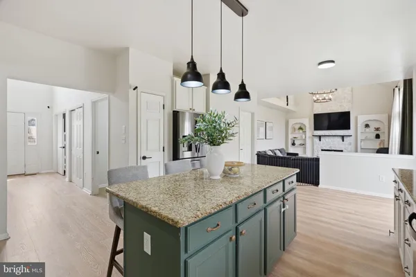 a kitchen with stainless steel appliances kitchen island granite countertop a stove a sink and a refrigerator